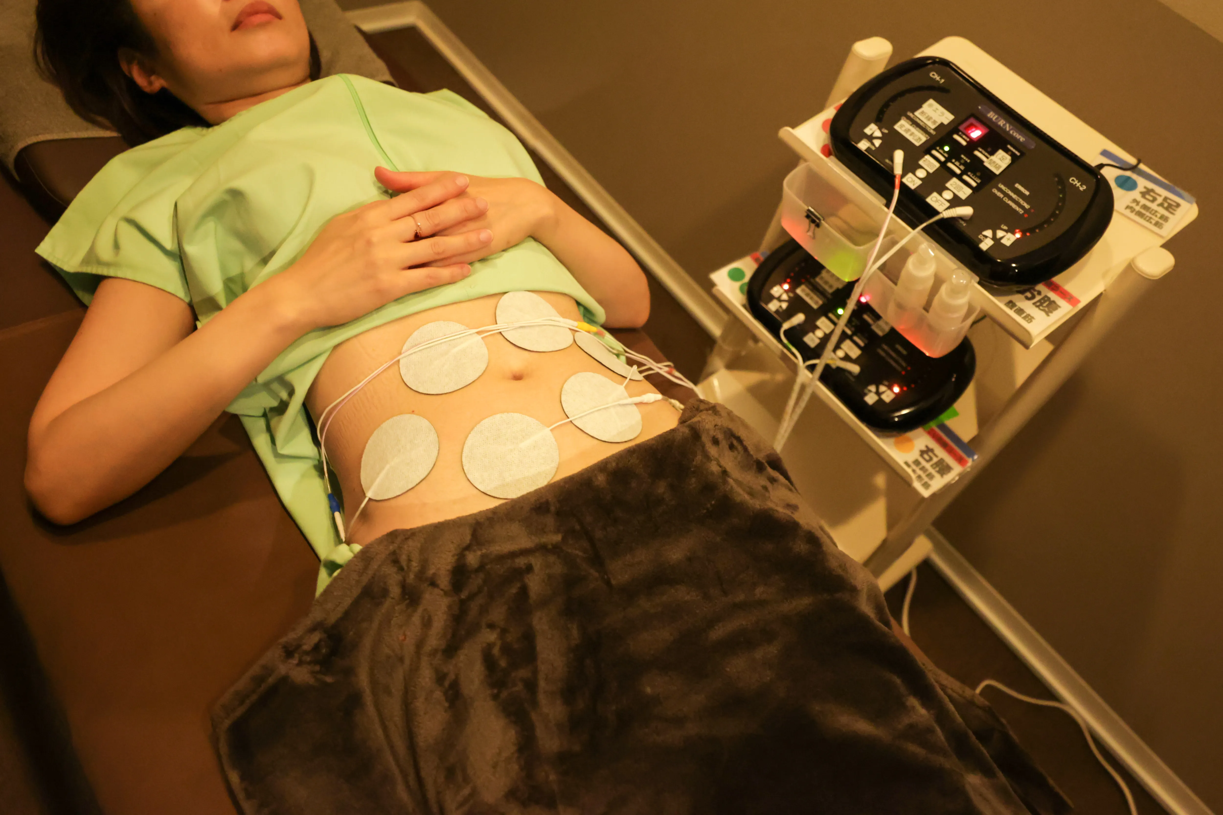 お腹に電極を貼られた女性の写真